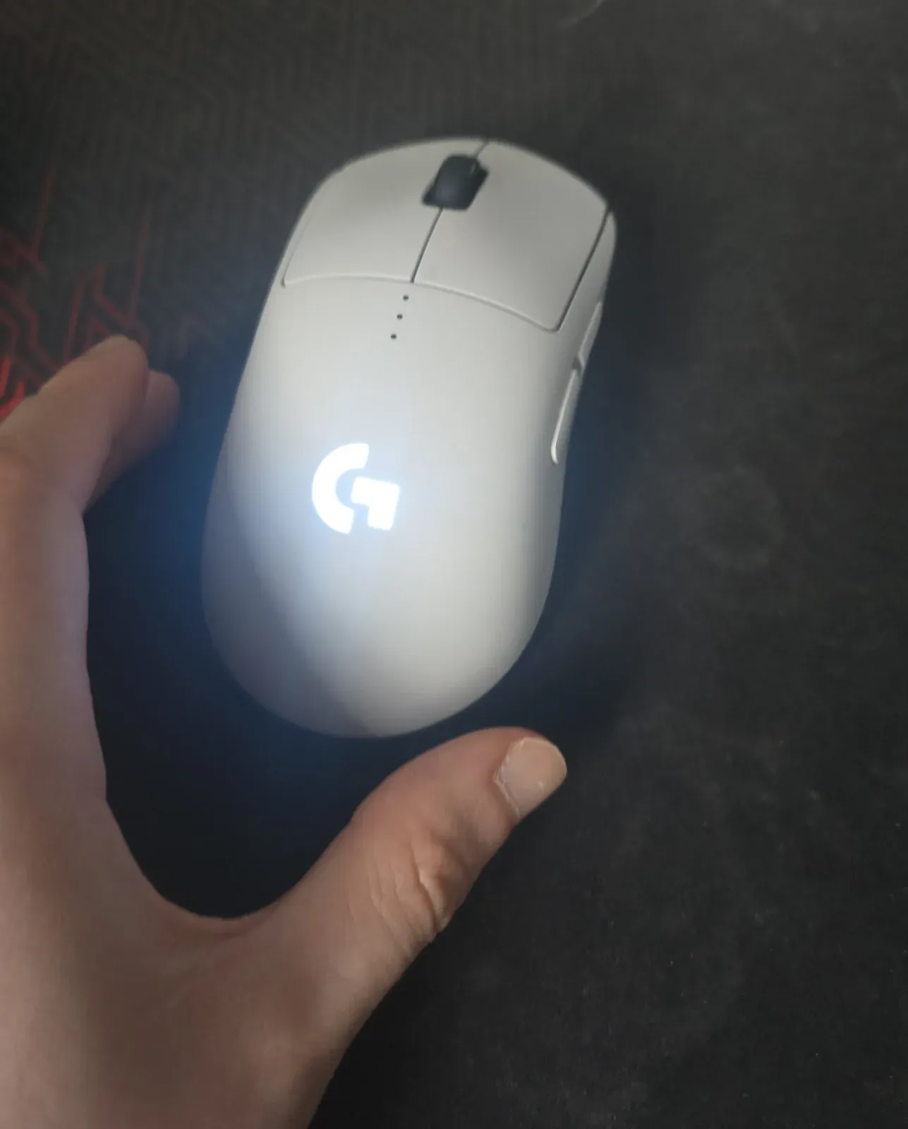 White Logitech PRO 2 LIGHTSPEED seen from above with a left hand cupping its right side